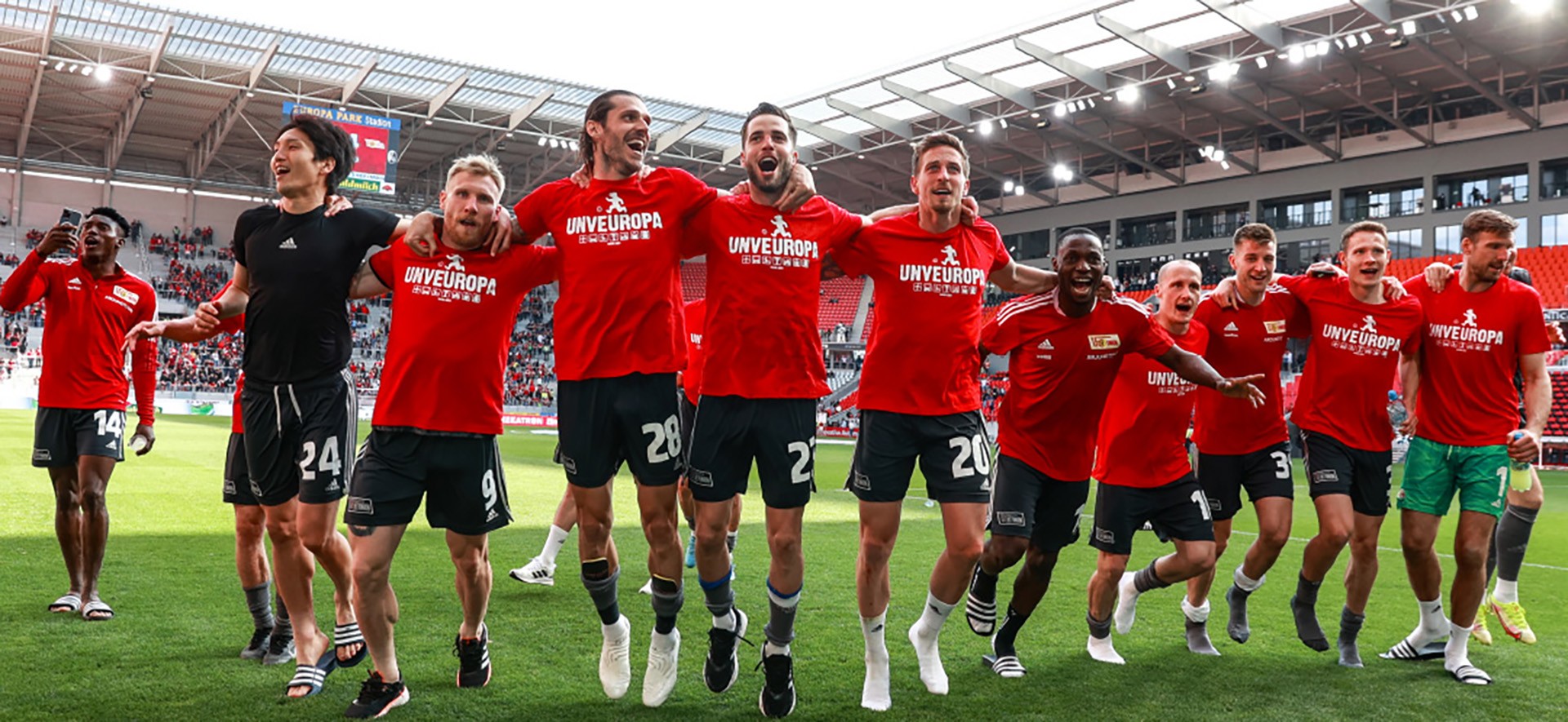 Eine Fußballmannschaft feiert ihren Sieg auf dem Rasen in einem Fußballstadion.